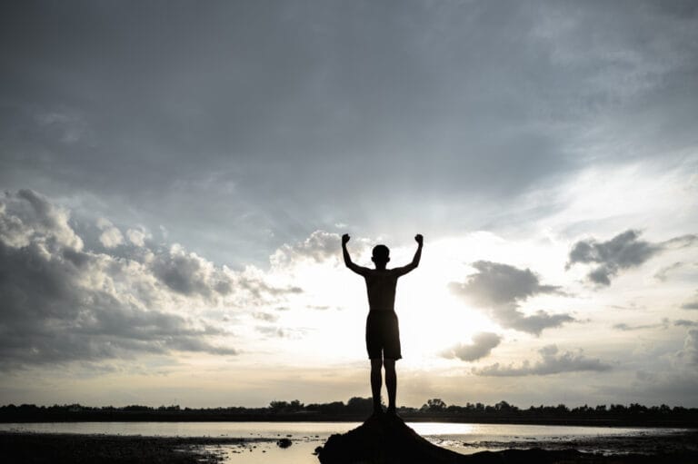 boy-raised-his-hand-sky-ask-rain-during-sunset